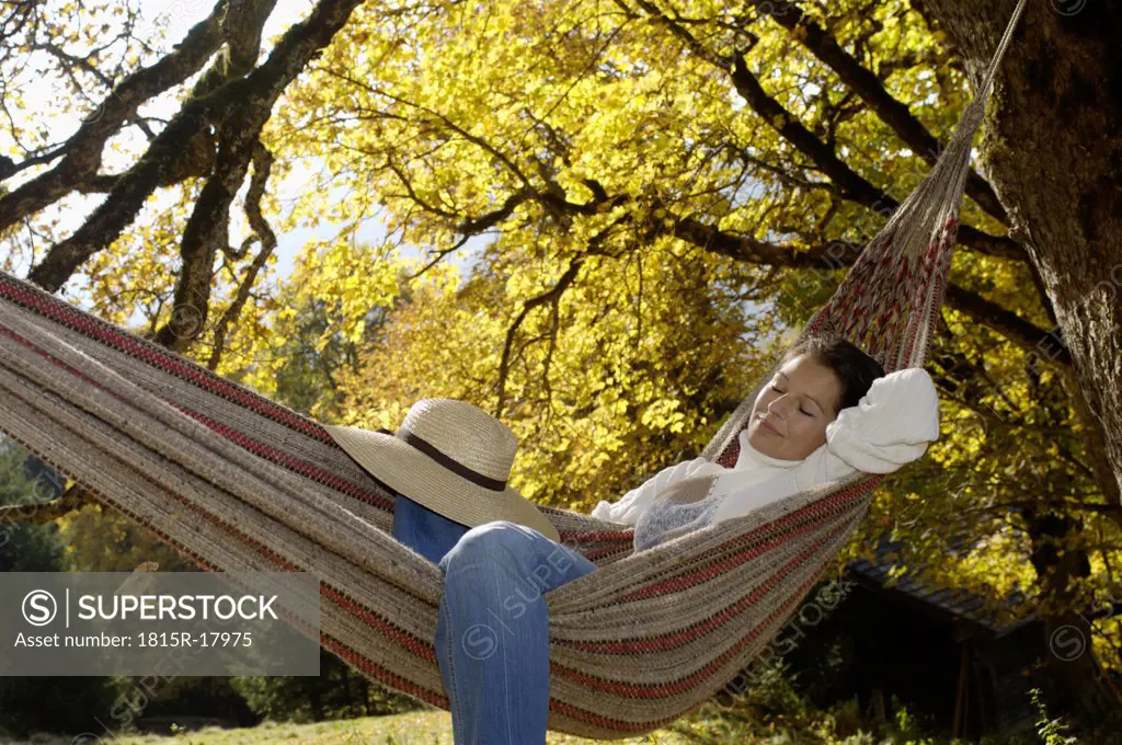 Woman lying in hammok, autumn