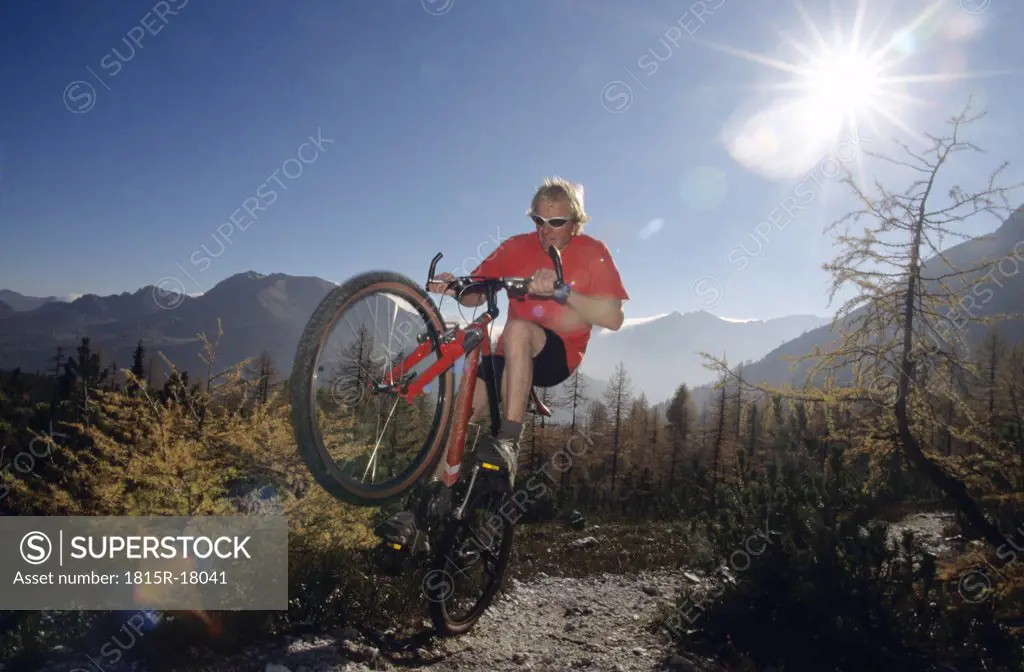 Austria, alps, man mountain biking, low angle view
