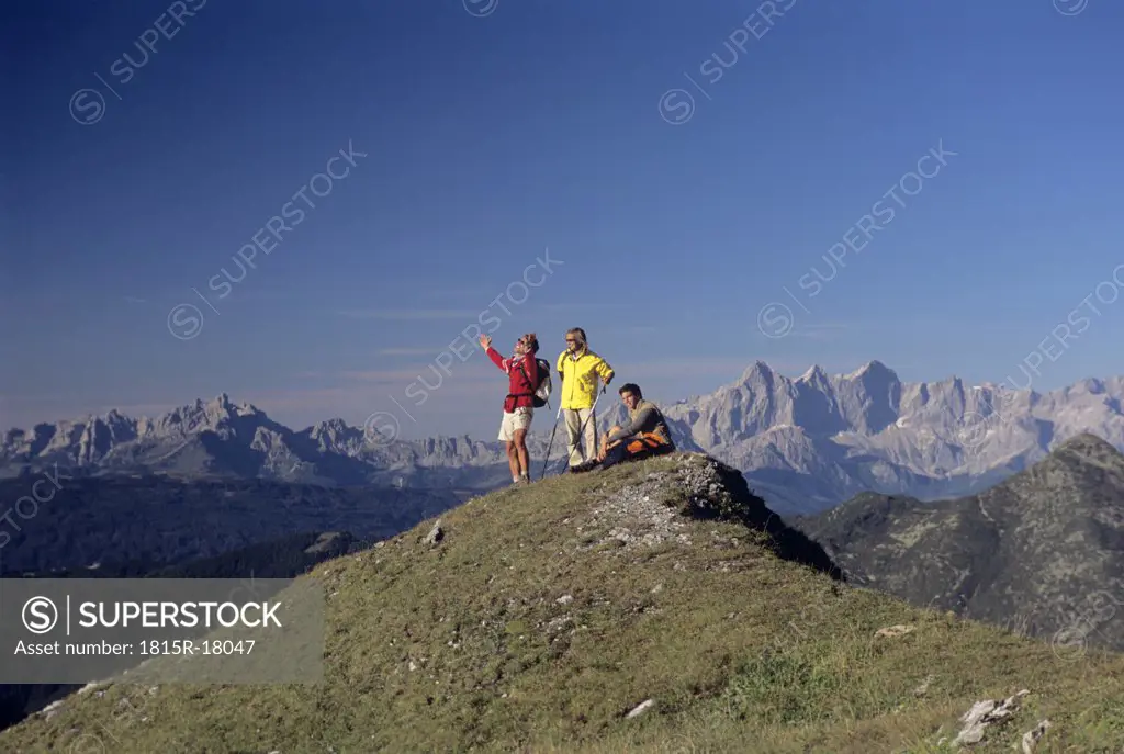 Three people on top of a mountain