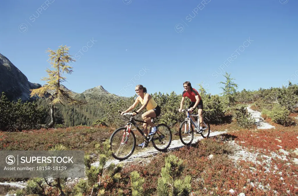 Couple riding bicycle in mountains