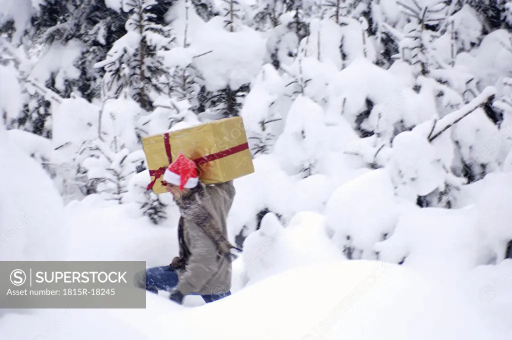 Man in snow, carrying a present