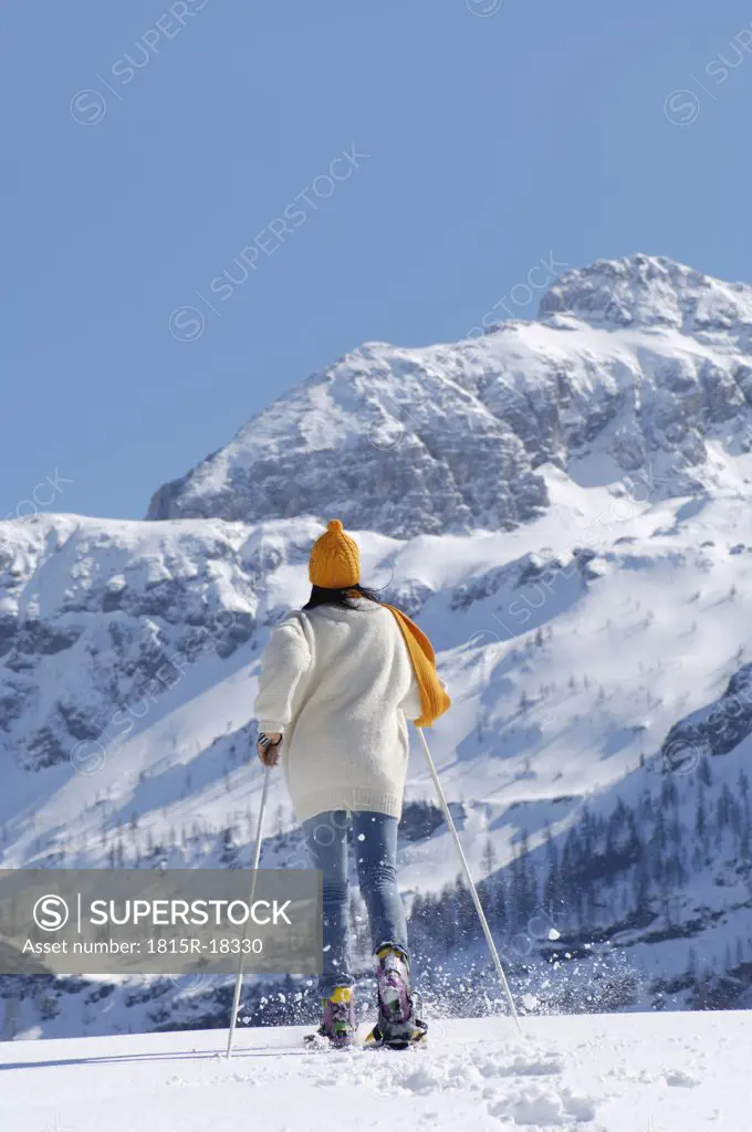 Woman snowshoeing, rear view