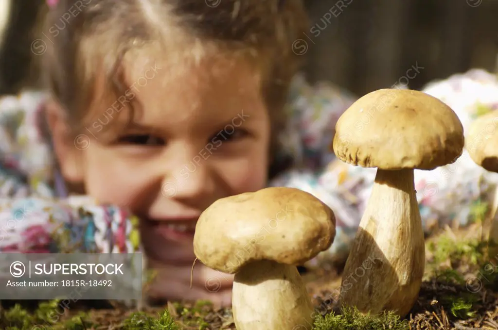 Girl watching ceps in forest