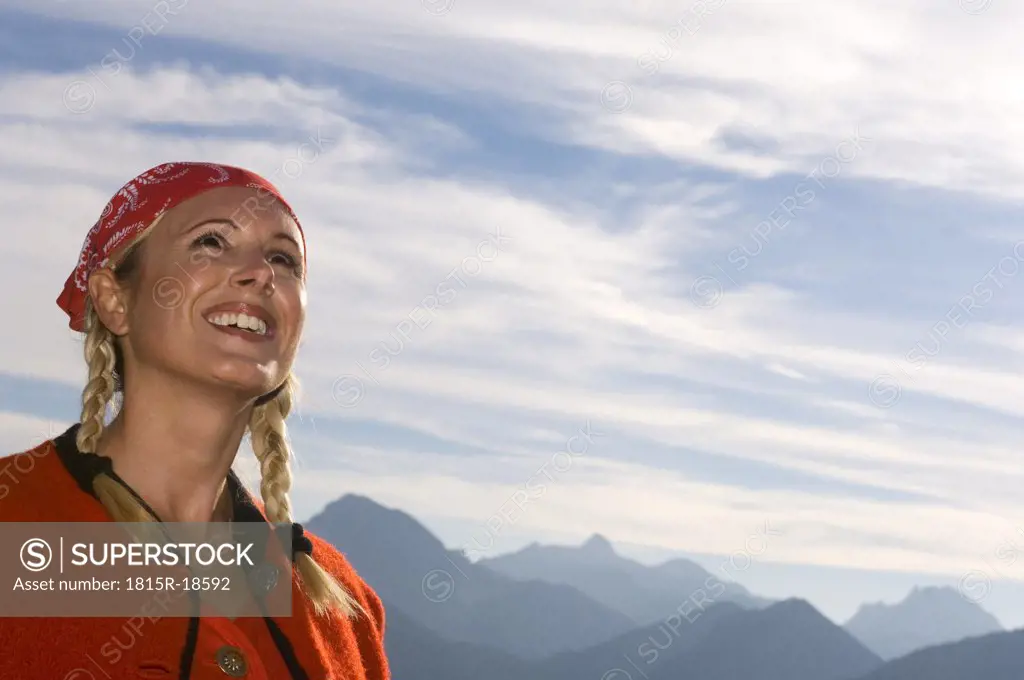 Young woman in mountains and looking up, low angle view, portrait