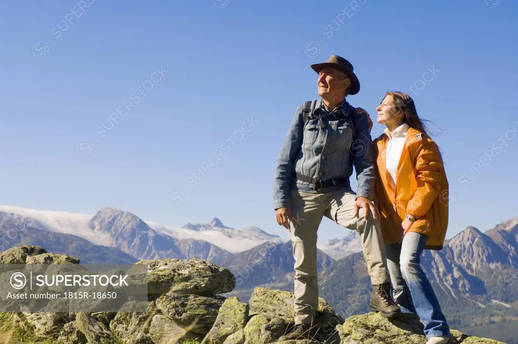 Couple in mountains, standing on rocks