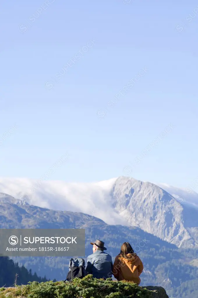 Couple in mountains, watching summits
