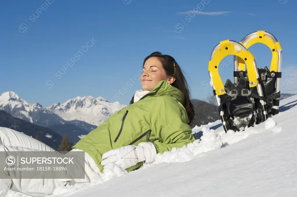 Woman with snowshoes, relaxing