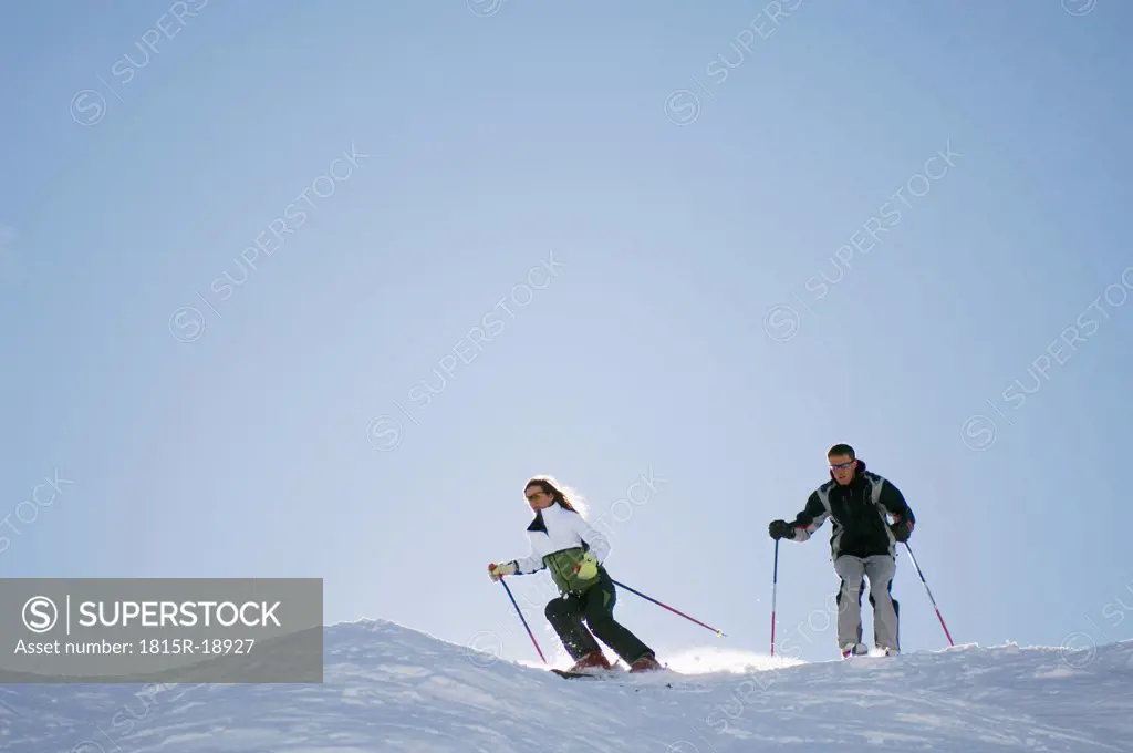 Austria, Salzburger Land, Couple skiing in mountains