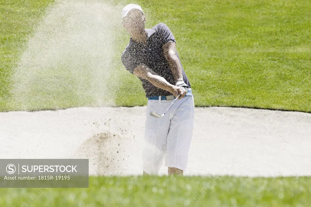 Golf player playing bunker shots