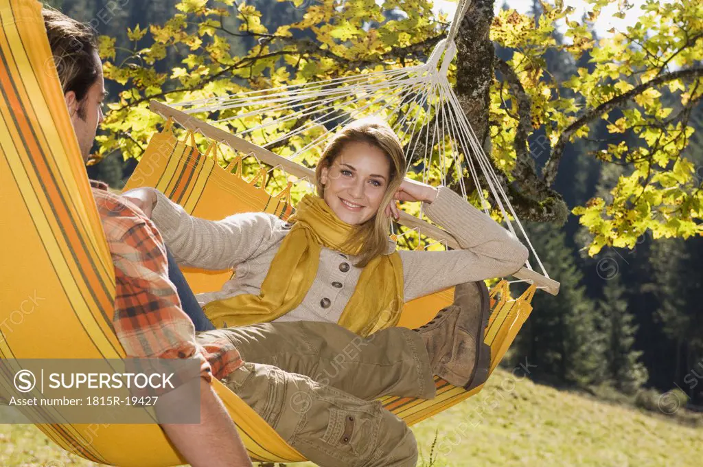 Austria, Salzburger Land, Altenmarkt, Couple lying in hammock, smiling, portrait