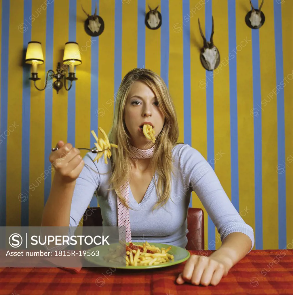 Young woman eating french fries