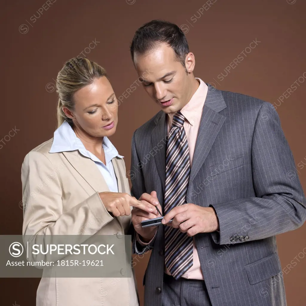 Businessman and businesswoman using electronic calendar