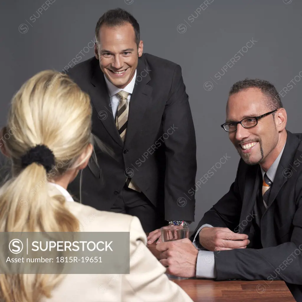 Business people having meeting at conference table, smiling