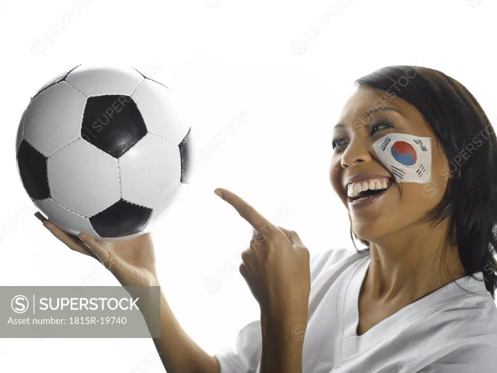 Woman with Korean flag painted on her face pointing at football, close-up