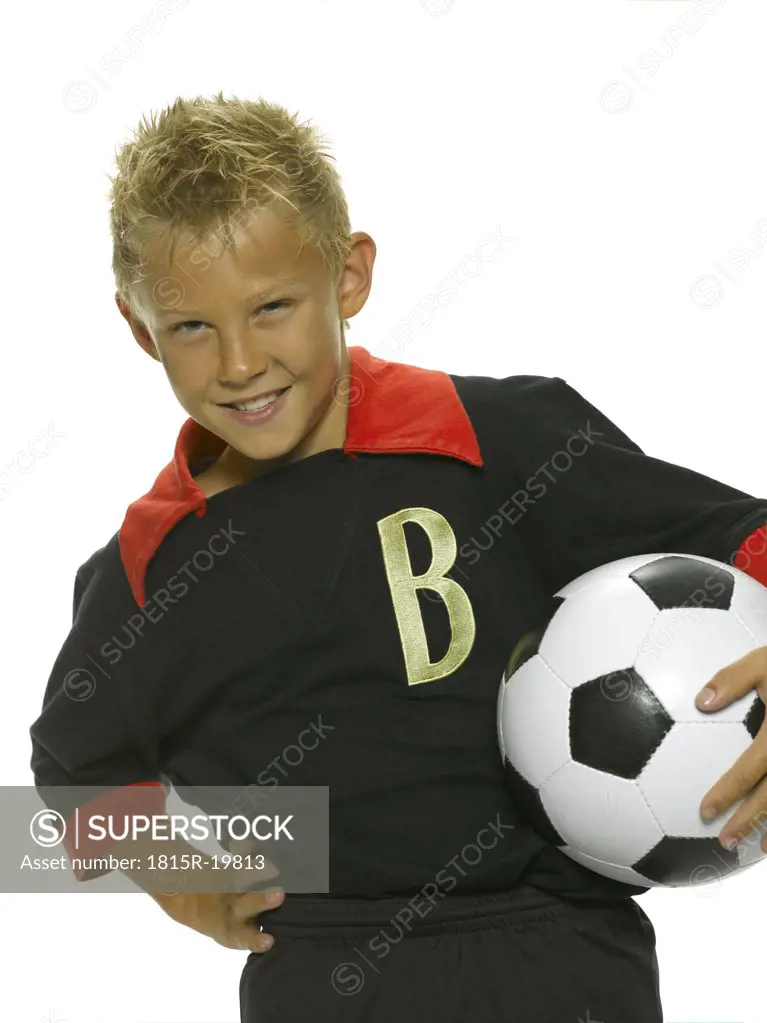 Boy (8-9) holding soccer ball, smiling, portrait, close-up