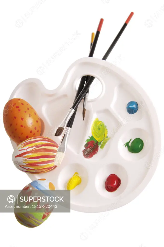 Palette with painted eggs and brushes, elevated view