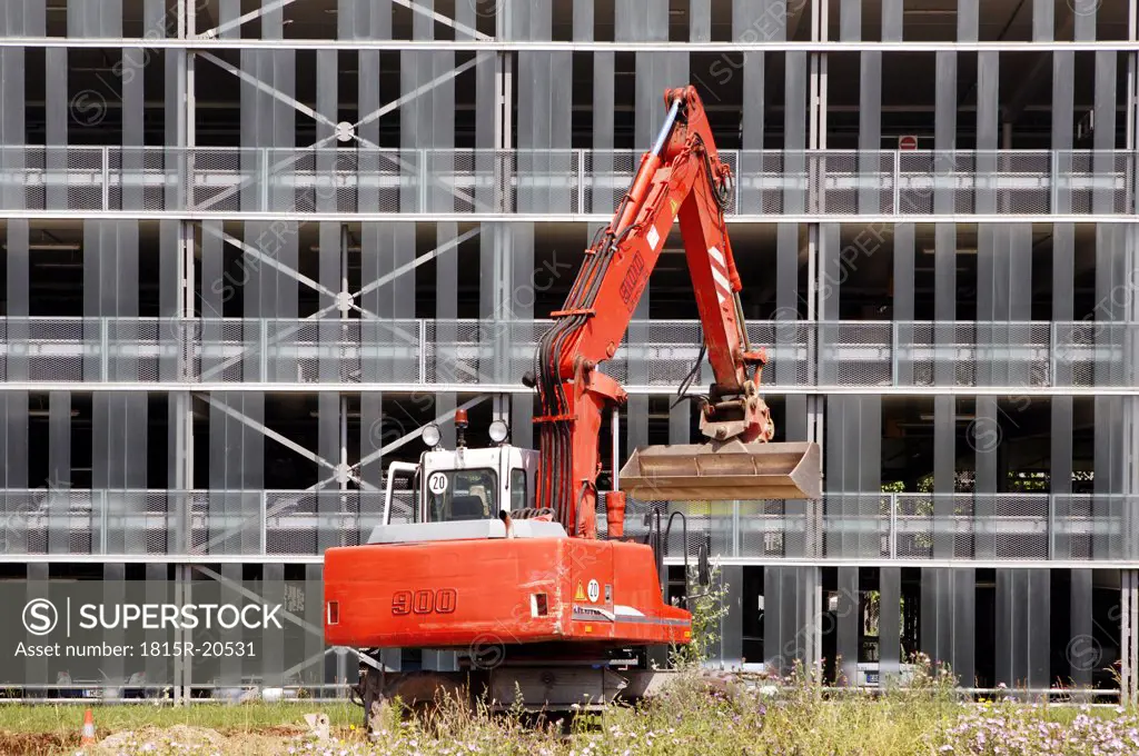 Excavator in front of house facade