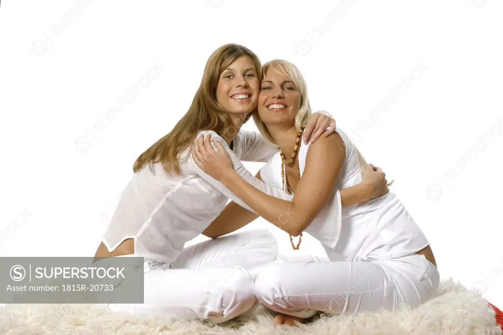 Two sitting woman embracing each other