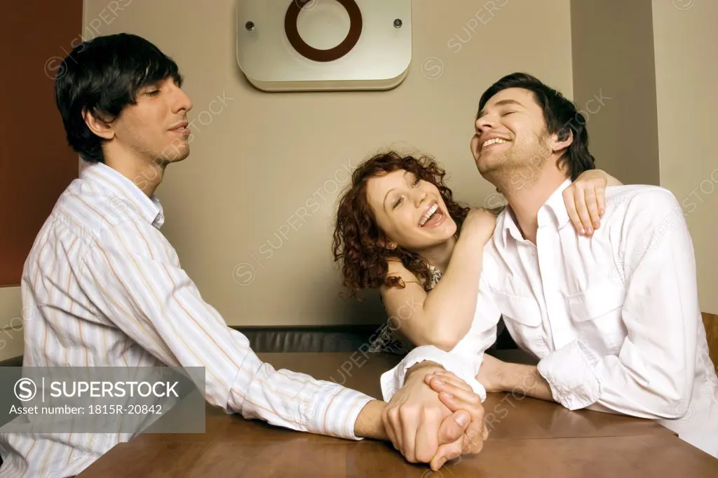 Women watching men arm wrestling, smiling