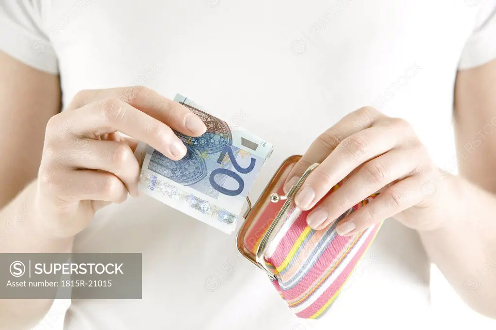 Woman putting money in change purse, close-up