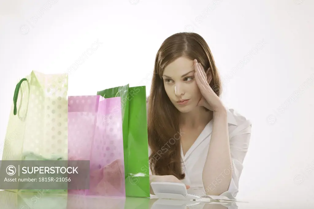 Young womanwith shopping bags, thinking, portrait