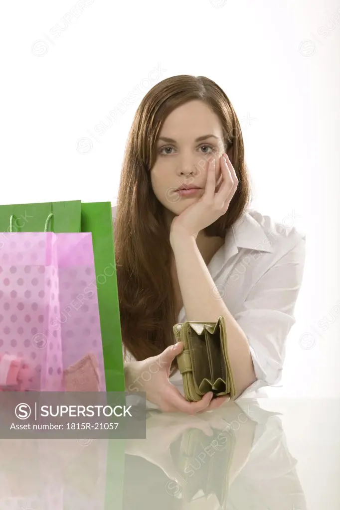 Young woman with shopping bags, thinking, portrait