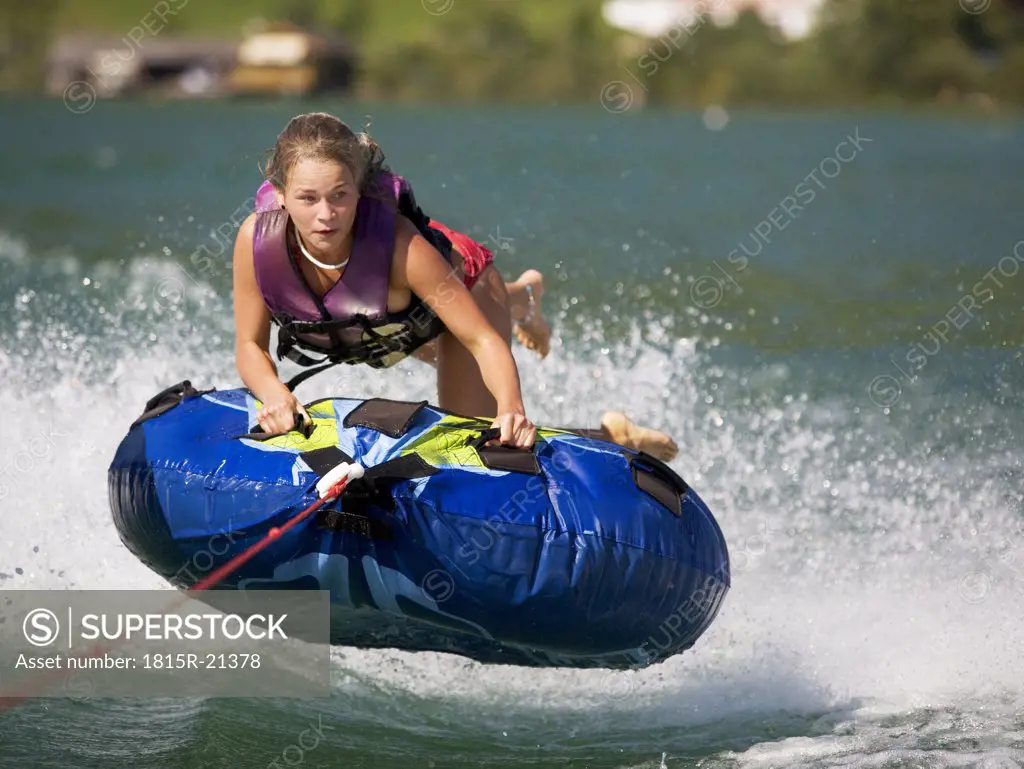 Austria, Moon Lake, Girl (16-17) riding water sled