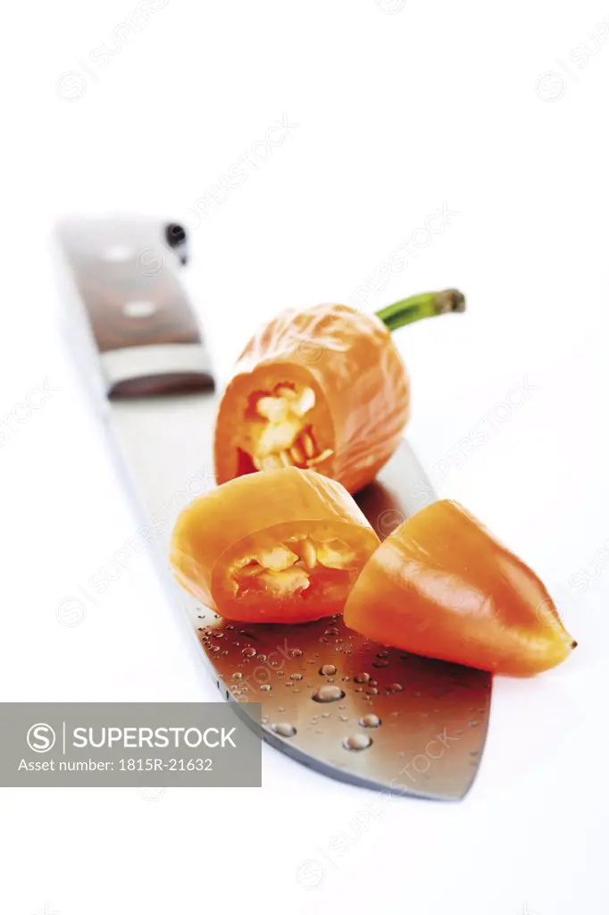 Orange Fresno pepper on knife blade, close-up