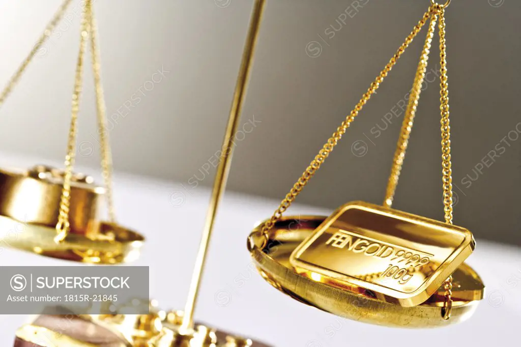 Gold bar on a a pair of scales