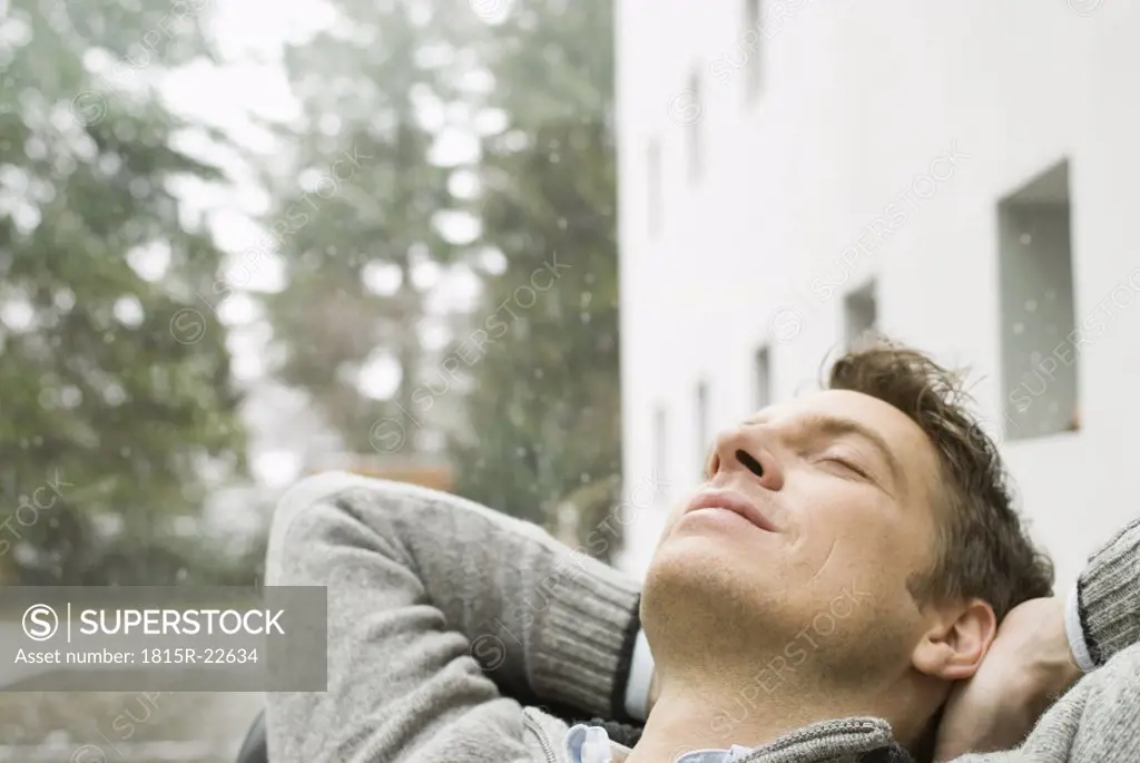 Man relaxing eyes closed hands behind neck