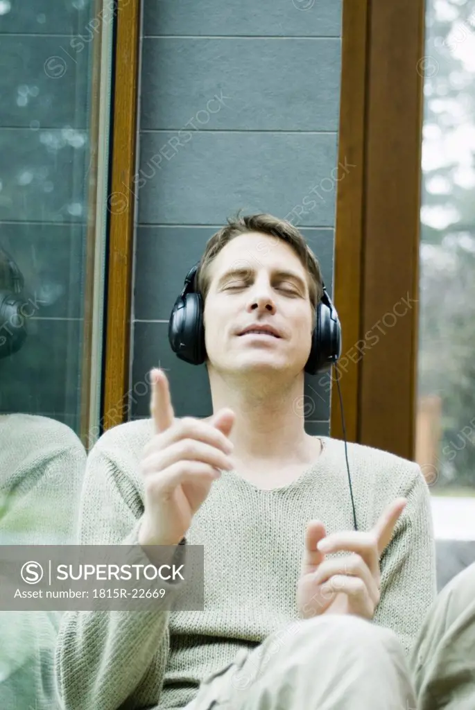 Man with headphones conducting eyes closed