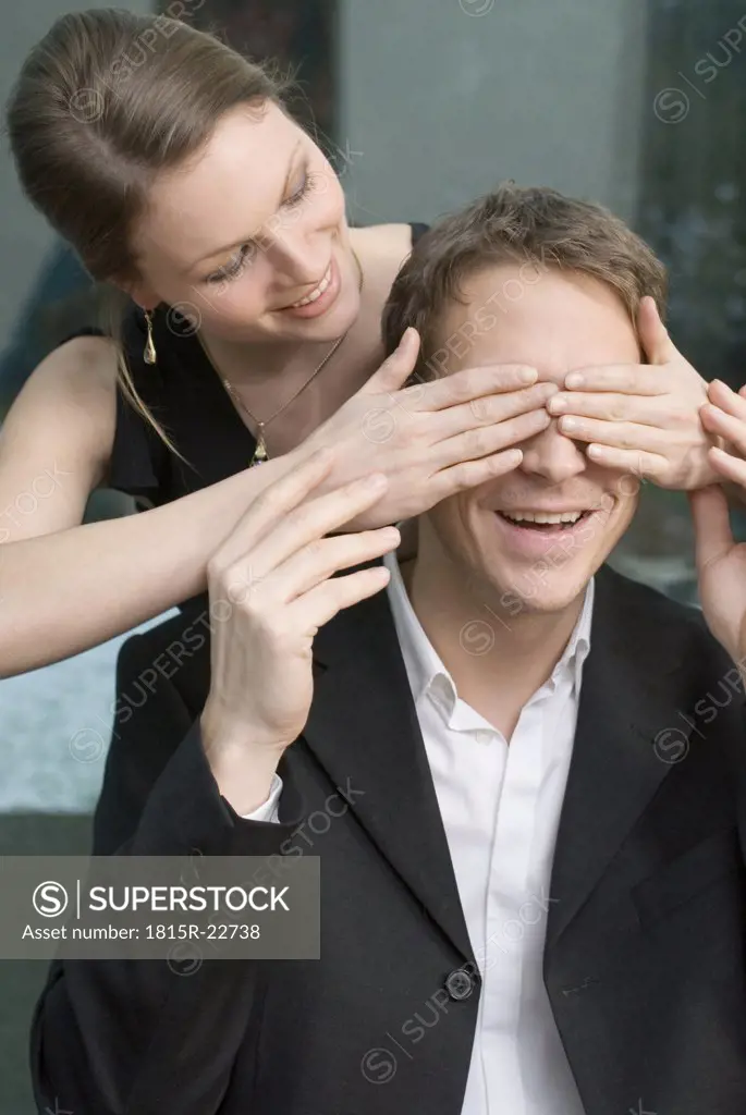Woman covering man's eyes with hands