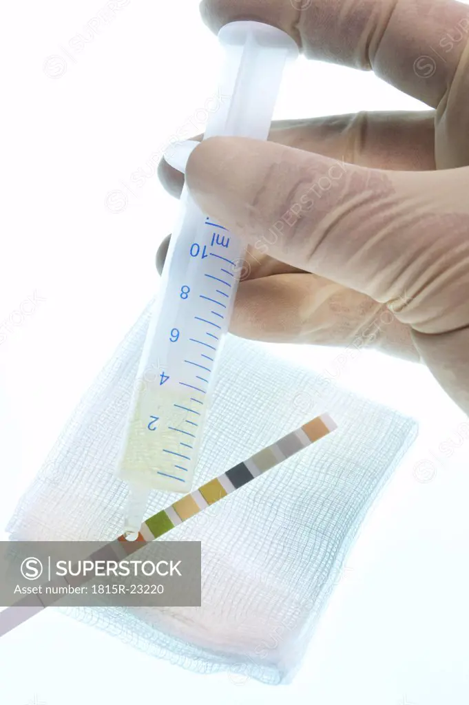 Person holding syringe, testing urine sample, close-up