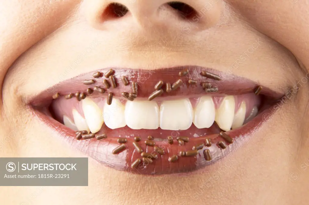 Young woman with chocolate granules on lips, detail