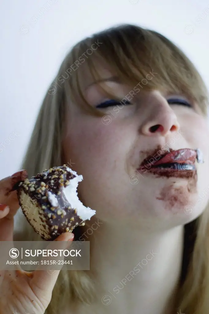 Young woman eating chocolate marshmallow