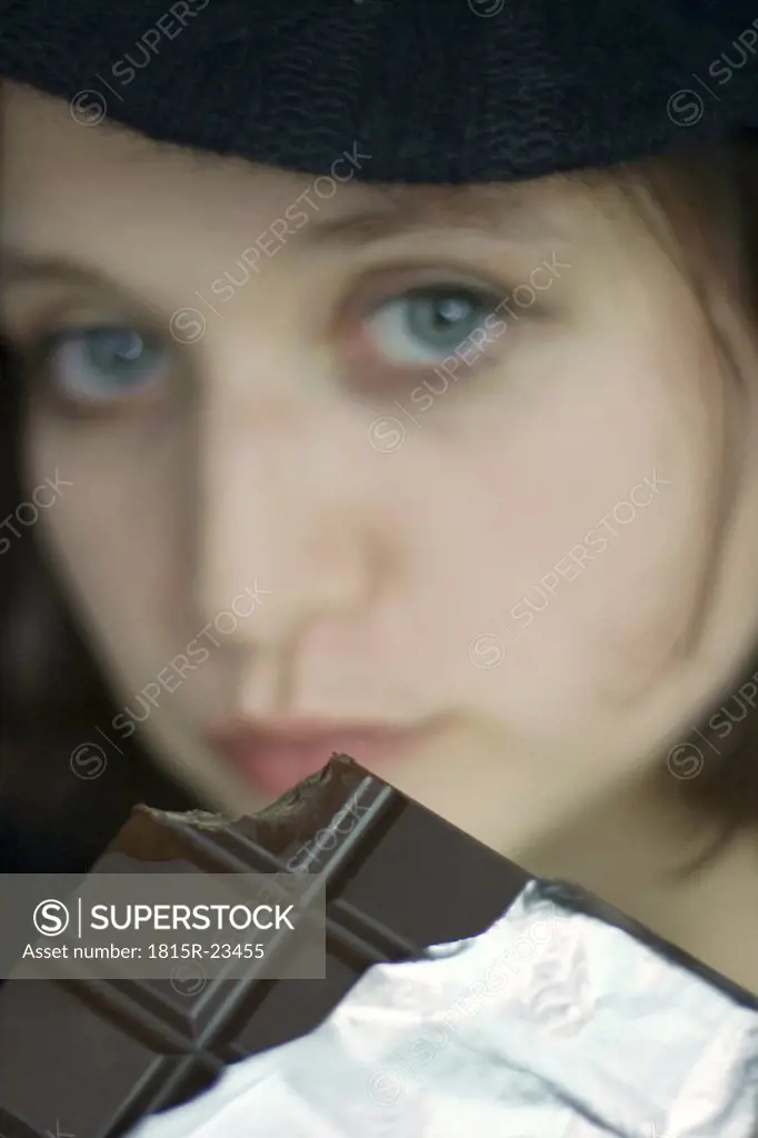 Young woman eating chocolate bar