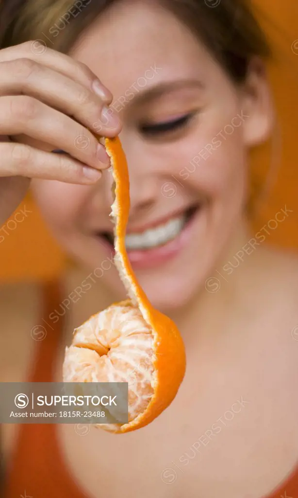 Young Woman holding tangerine, close-up