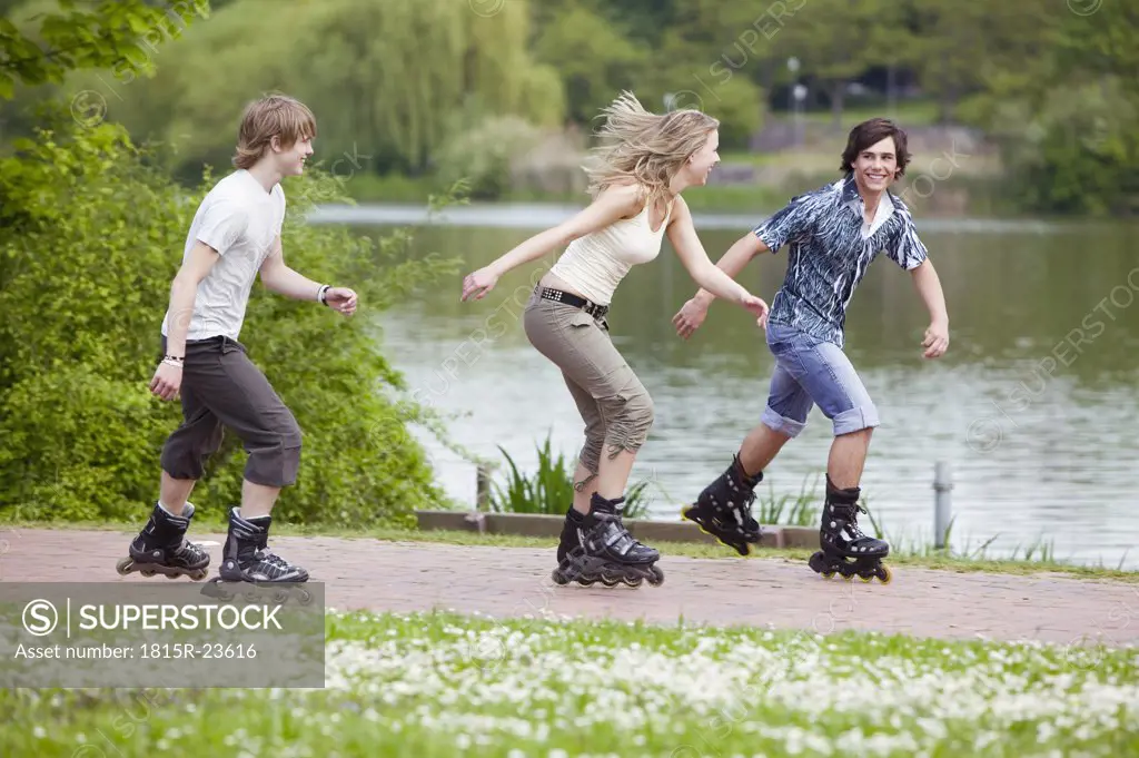 Teenagers inline skating, smiling