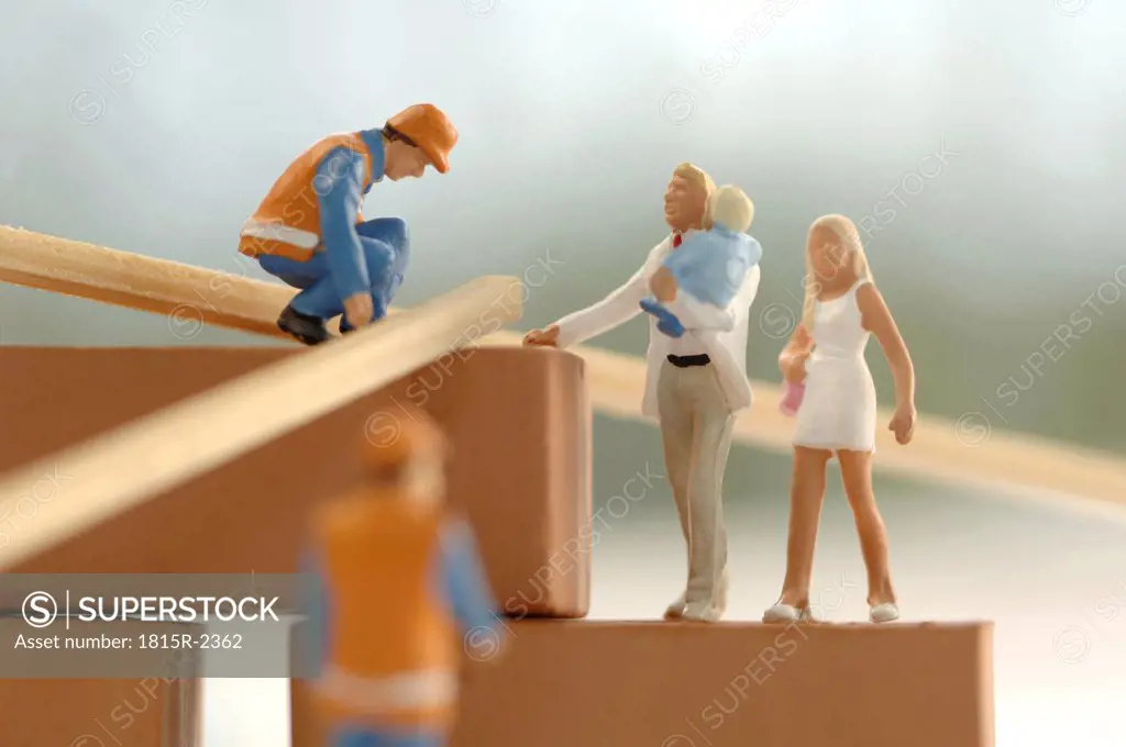 Figurines of construction workers and family at construction site