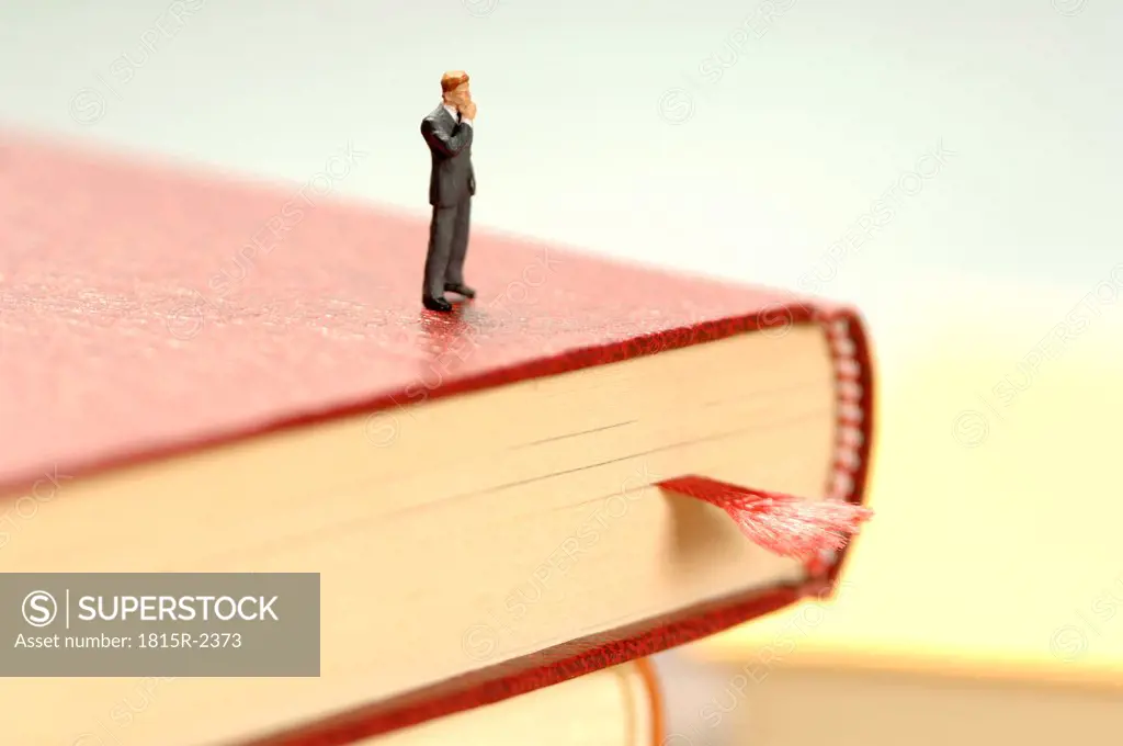 Figurine of man kept on book, close-up