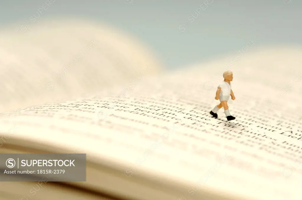 Child walking over book, figurine