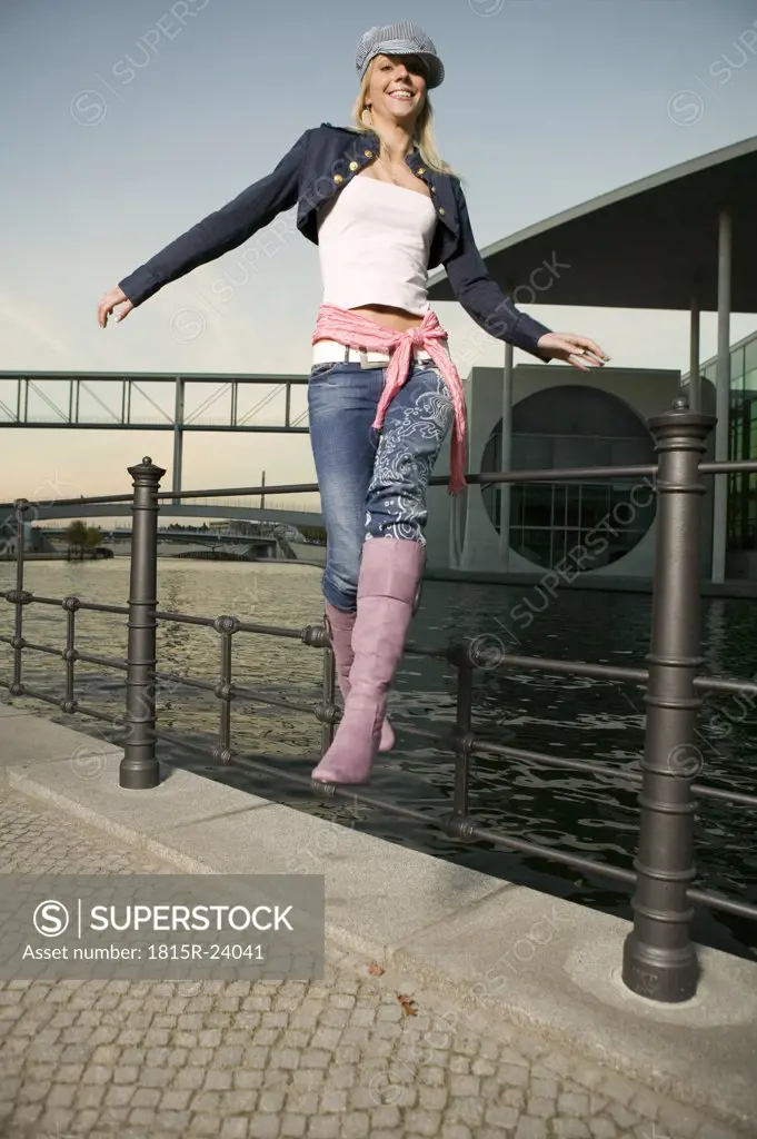 Young woman jumping from railing