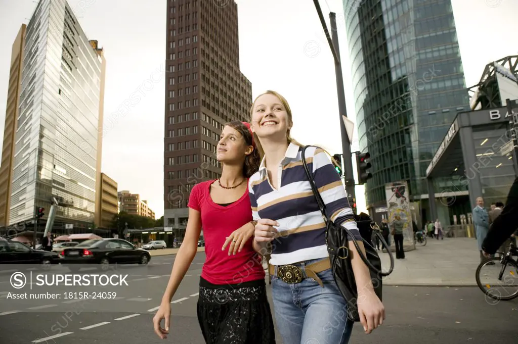 Two girl friends strolling in city