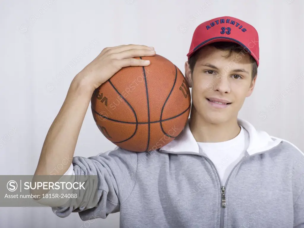 Boy ( 16-17) holding basket ball, portrait