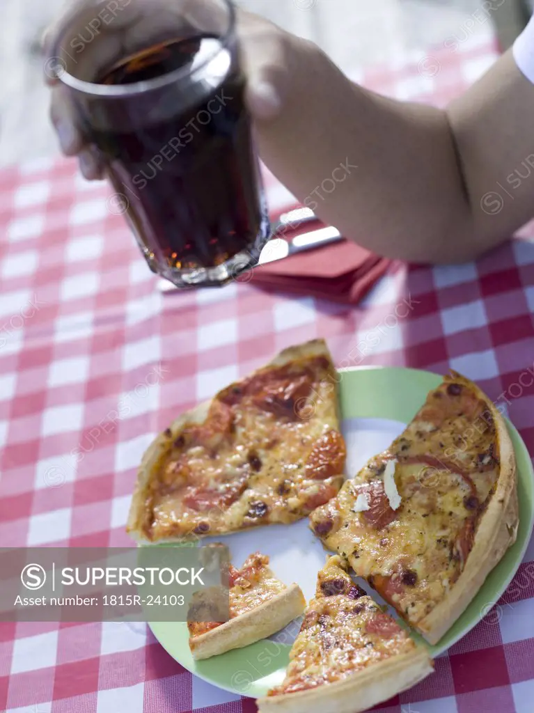 Pizza on plate, young man holding glass