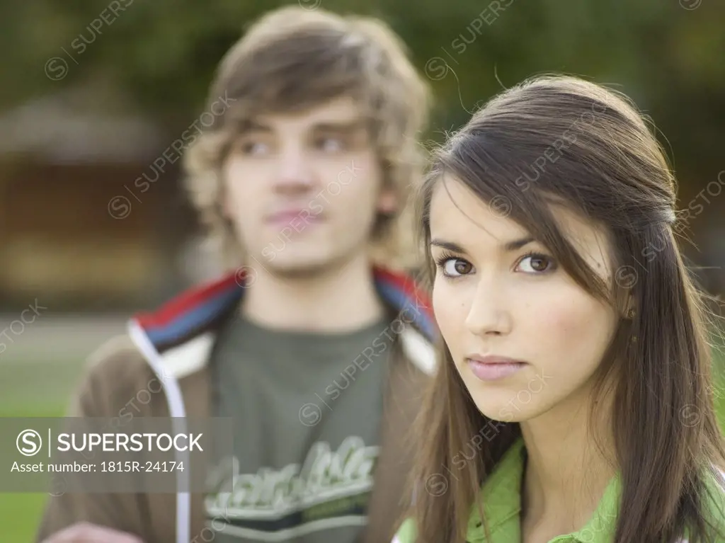 Young woman, portrait, young man in background