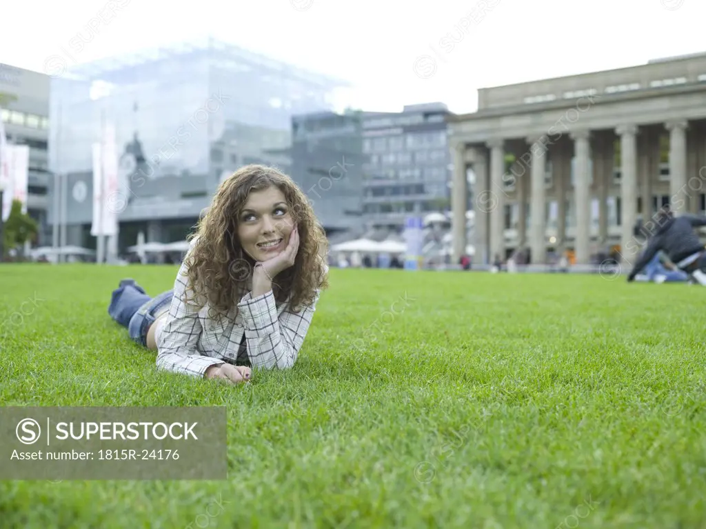 Germany, Stuttgart, young woman lying in meadow