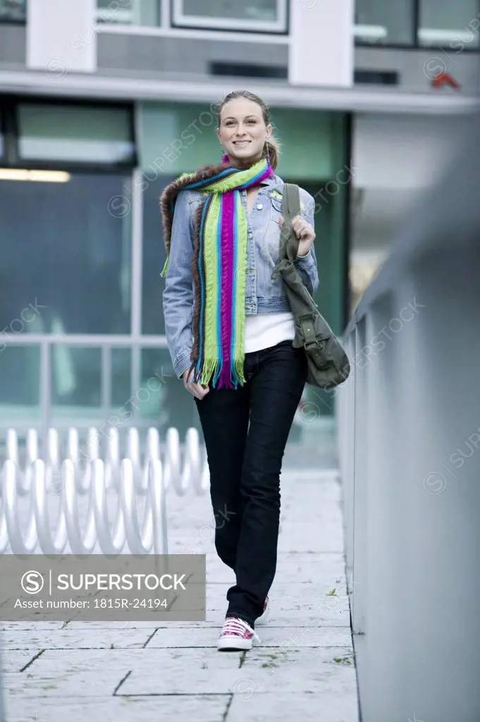 Young woman wearing scarf, walking