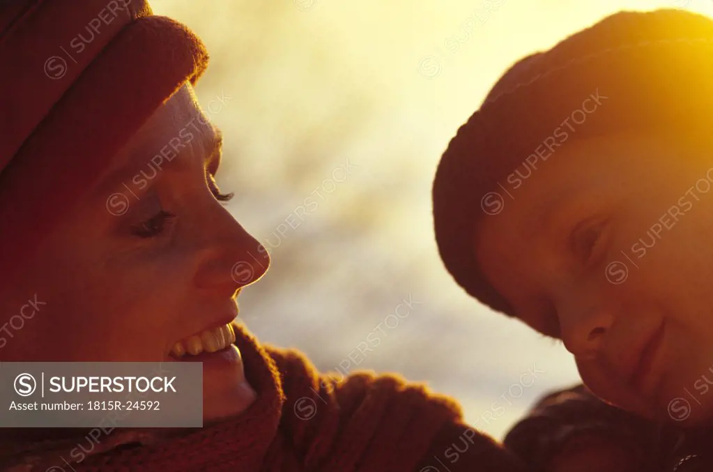 Mother and child (4-7) smiling outdoors