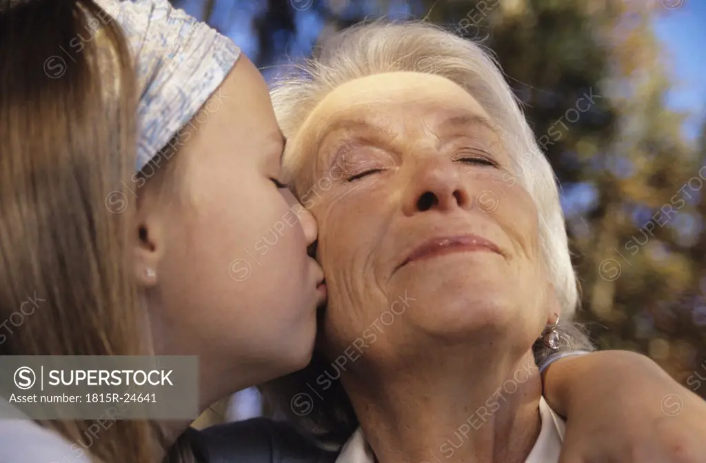 Granddaughter kissing grandmother